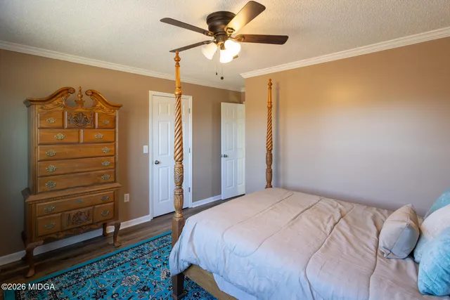 a bedroom with a bed and a ceiling fan