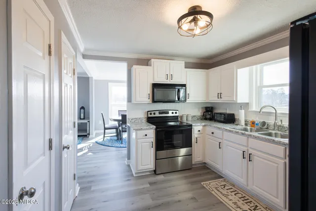 a kitchen with stainless steel appliances granite countertop a stove a sink and a refrigerator