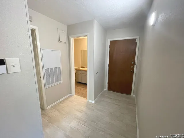 an empty room with wooden floor and mirror