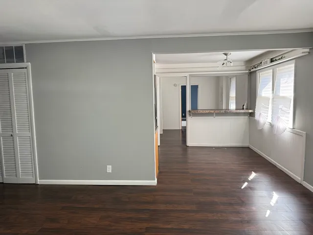 a view of a kitchen with wooden floor and a window