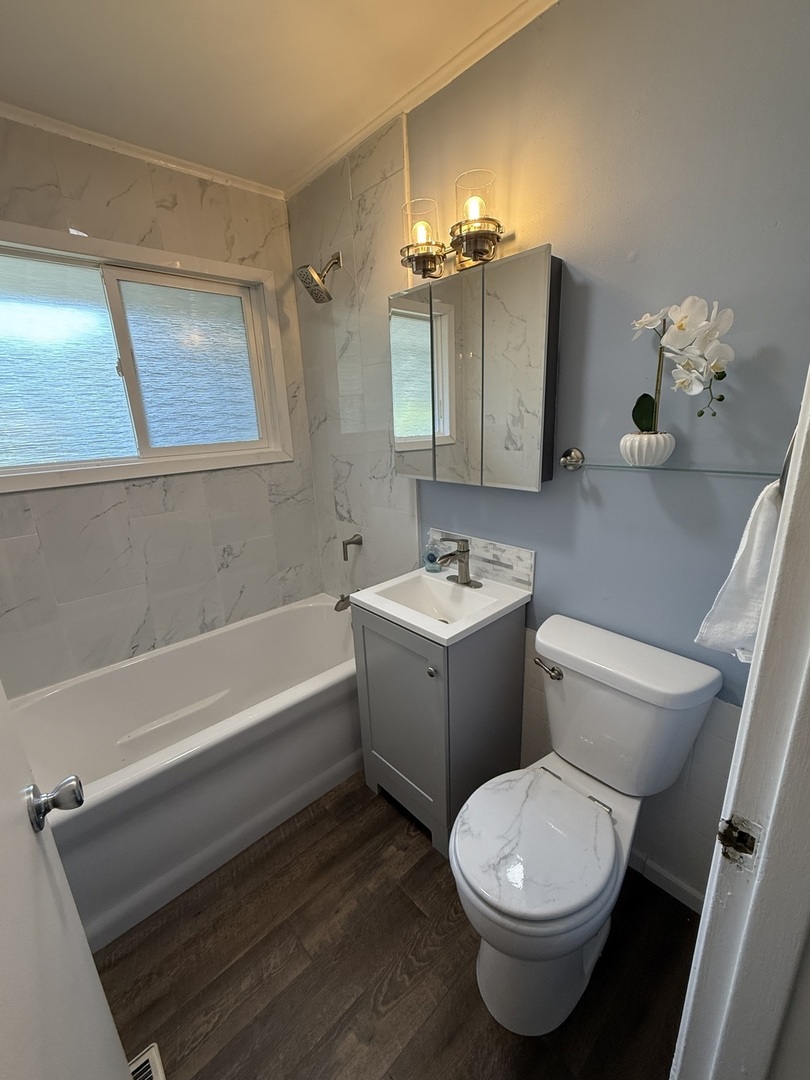 16939 Jodave Avenue Hazel Crest, IL 60429 - Photo 4 of 10 a bathroom with a sink a toilet a mirror and shower