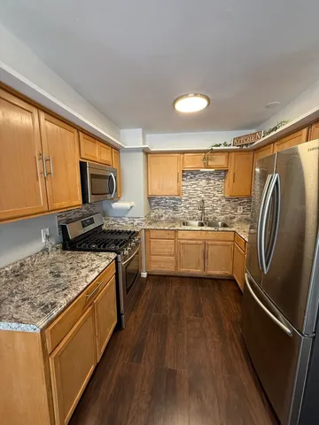 a view of a kitchen with wooden floor and a refrigerator