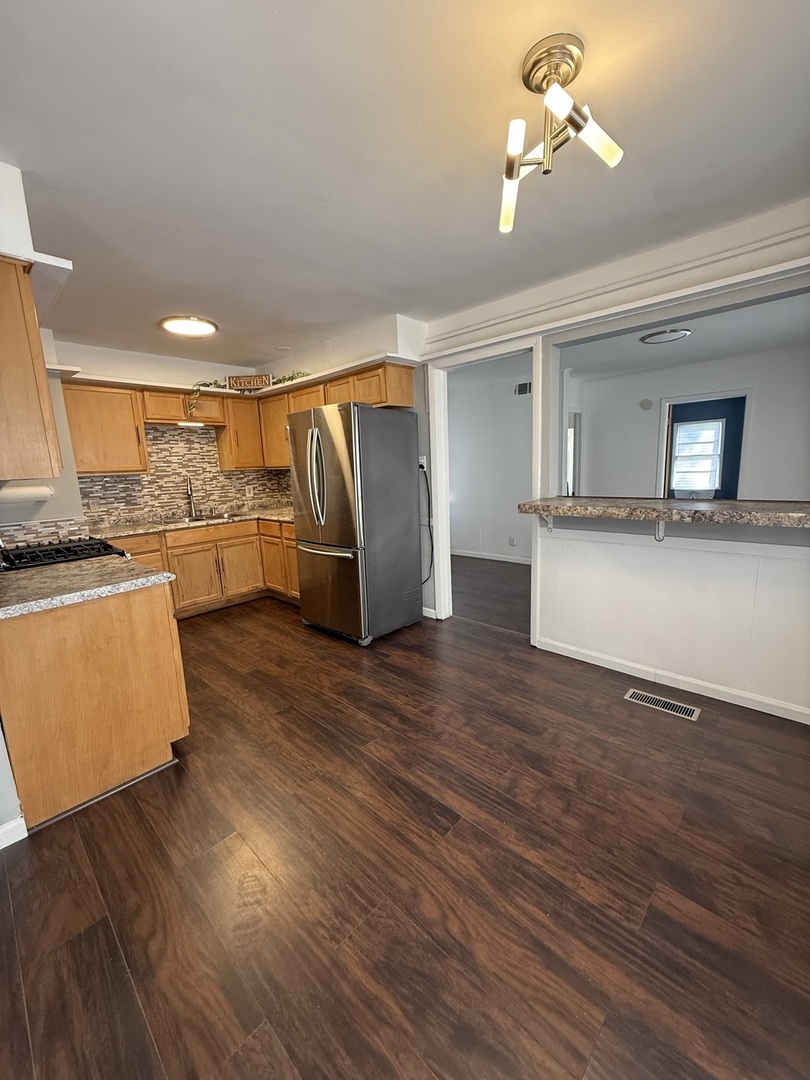 16939 Jodave Avenue Hazel Crest, IL 60429 - Photo 7 of 10 a view of a kitchen with wooden floor and a refrigerator