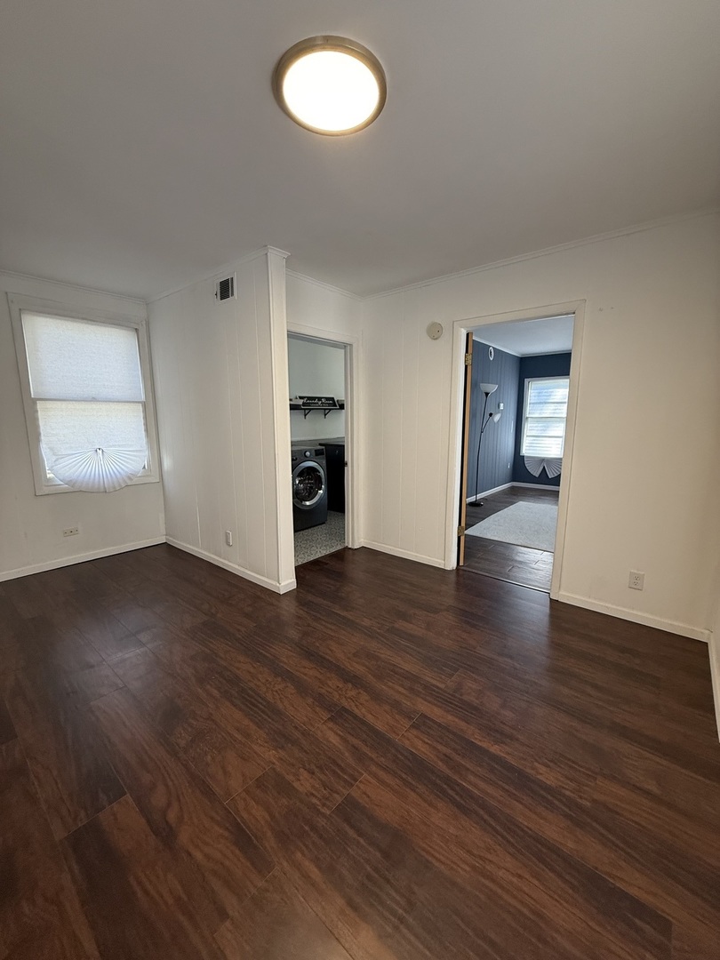 16939 Jodave Avenue Hazel Crest, IL 60429 - Photo 8 of 10 an empty room with wooden floor and windows