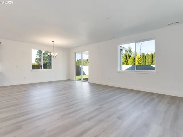 a view of empty room with wooden floor and fireplace