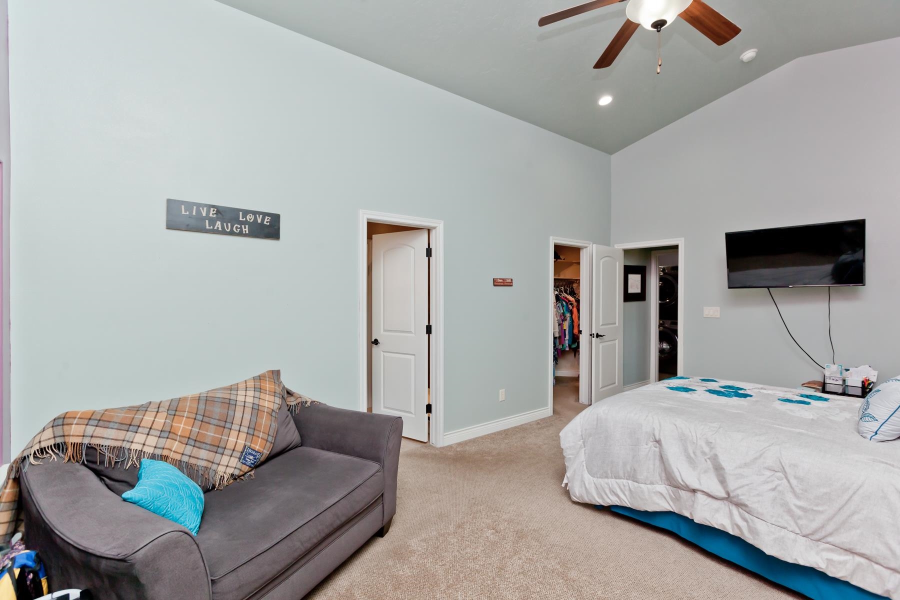 1037 Wingate Drive Fruita, CO 81521 - Photo 11 of 42 a bedroom with a bed a couch and a chandelier