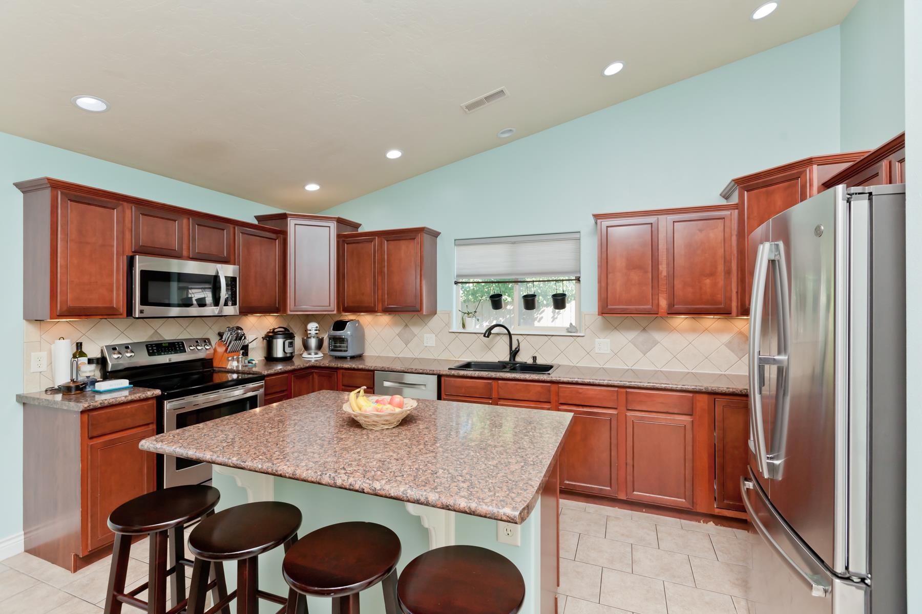 1037 Wingate Drive Fruita, CO 81521 - Photo 2 of 42 a kitchen with stainless steel appliances granite countertop a table chairs sink refrigerator and microwave