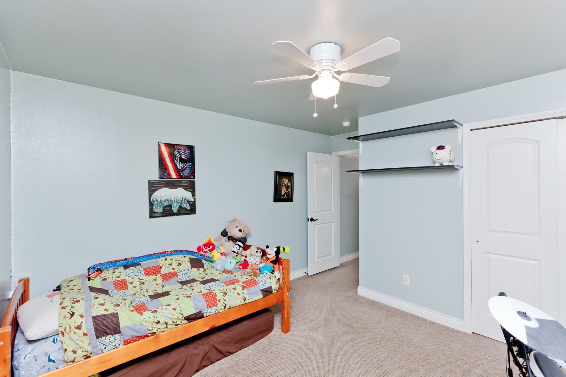1037 Wingate Drive Fruita, CO 81521 - Photo 22 of 42 a bedroom with a bed and a chandelier