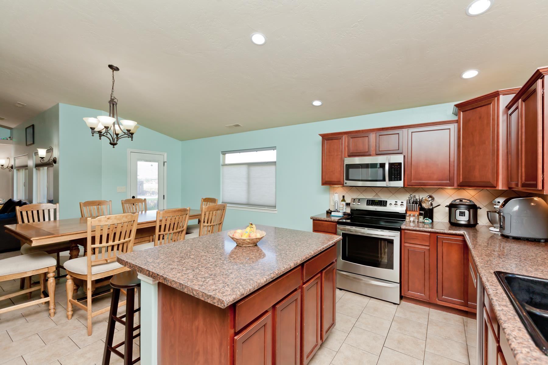 1037 Wingate Drive Fruita, CO 81521 - Photo 3 of 42 a kitchen with stainless steel appliances granite countertop a stove top oven a sink dishwasher a dining table and chairs with wooden floor