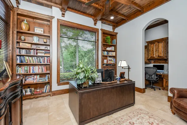 a view of a workspace with furniture and a window