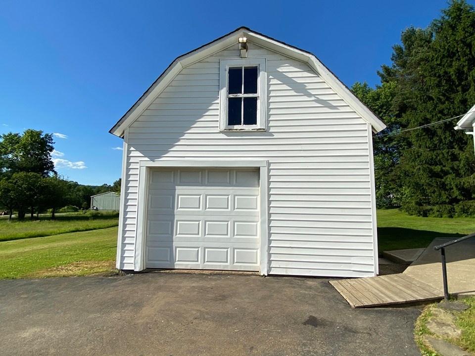 54 Eldred Center Road Grand Valley, PA 16420 - Photo 22 of 27 a front view of a house with a yard and garage