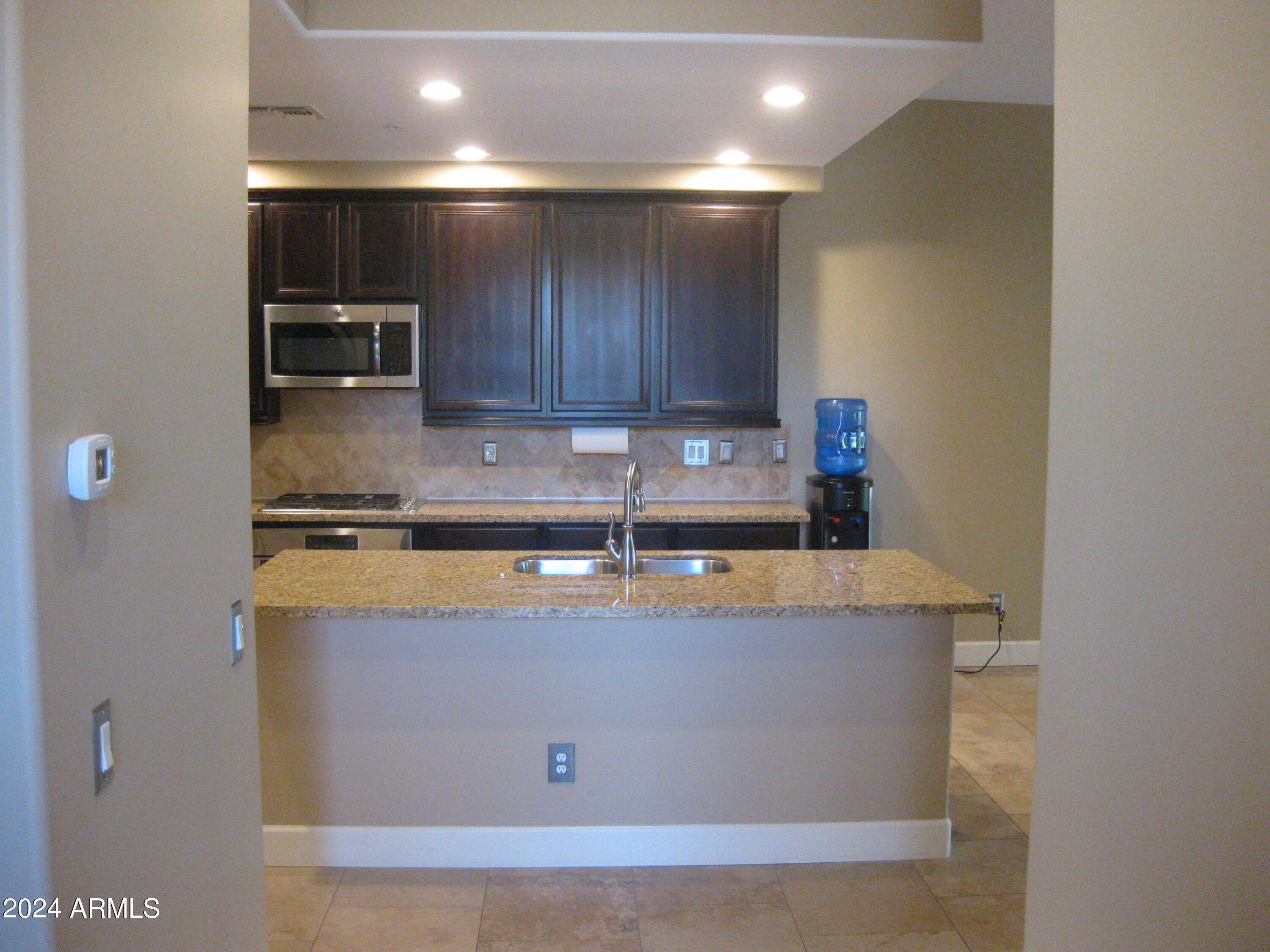 36600 North Cave Creek Road, Unit C20 Cave Creek, AZ 85331 - Photo 2 of 32 a kitchen with stainless steel appliances granite countertop a sink a stove and a refrigerator with wooden floor