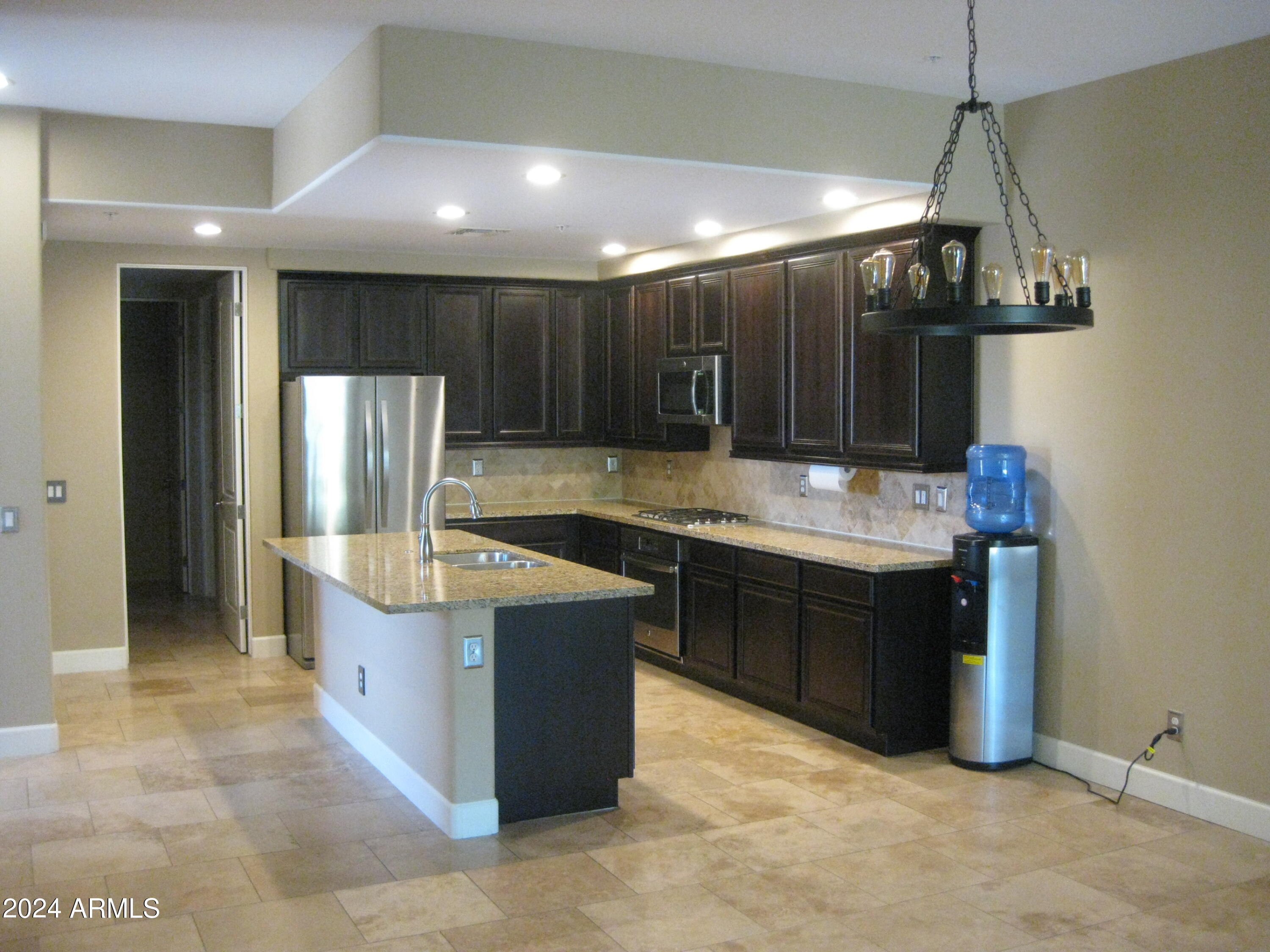 36600 North Cave Creek Road, Unit C20 Cave Creek, AZ 85331 - Photo 3 of 32 a kitchen with kitchen island granite countertop a sink and a refrigerator
