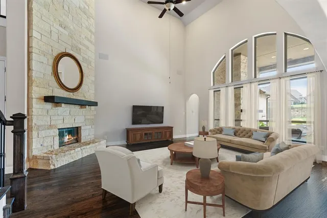 a living room with furniture a fireplace and a floor to ceiling window