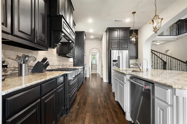 a kitchen with stainless steel appliances granite countertop lots of counter top space and wooden floor