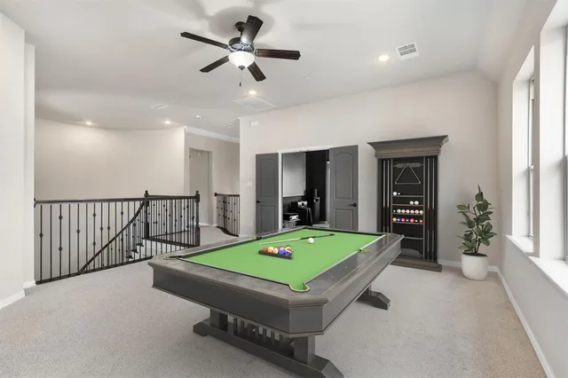 a room with pool table and windows