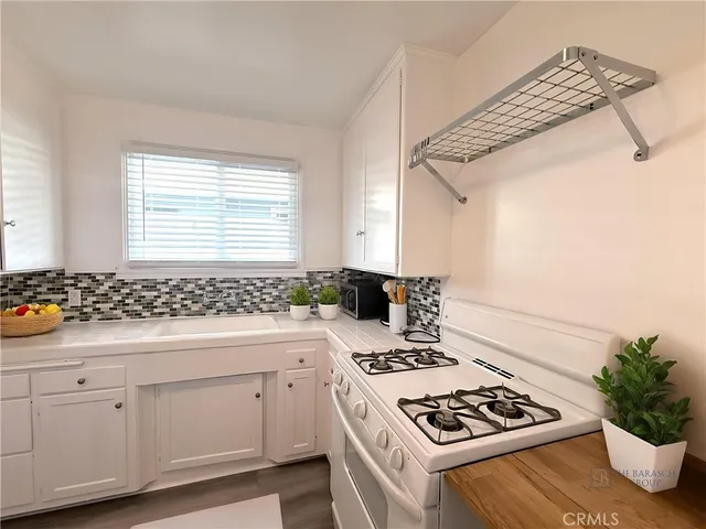 a kitchen with a stove and white cabinets
