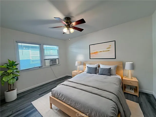 a bedroom with a large bed and a potted plant