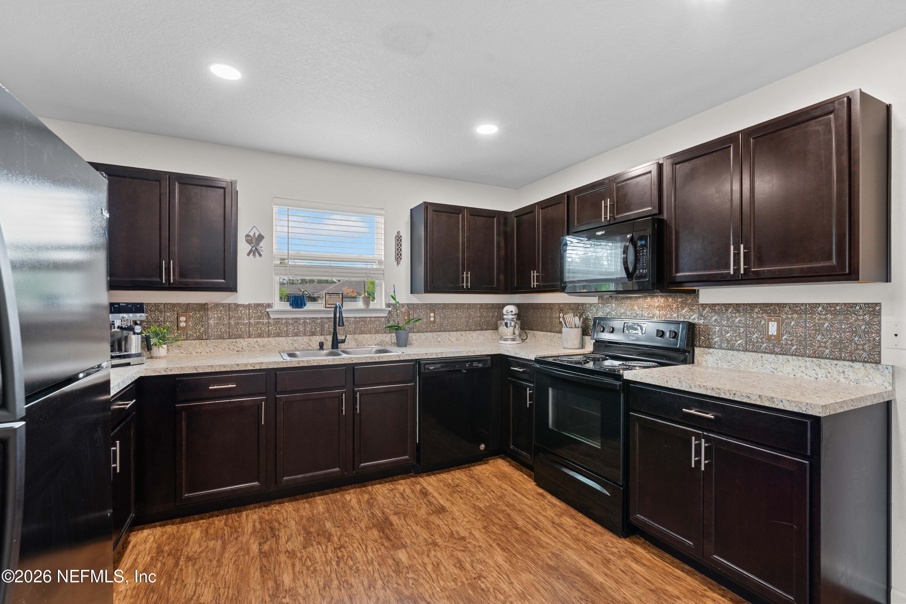 6178 Daylilly Road Macclenny, FL 32063 - Photo 13 of 29 a kitchen with a sink stove and cabinets