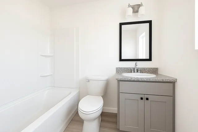 a bathroom with a granite countertop sink toilet and shower