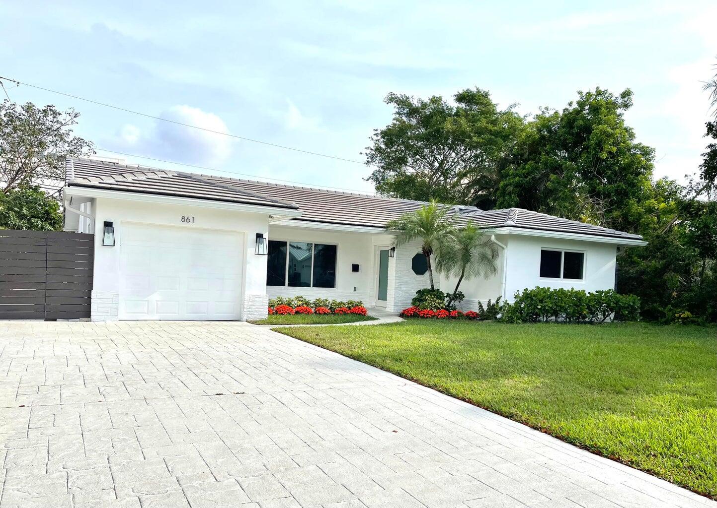 861 Northwest 7th Street Boca Raton, FL 33486 - Photo 1 of 18 a front view of a house with a garden and trees