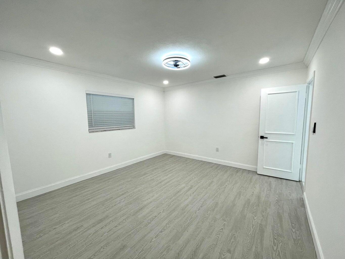861 Northwest 7th Street Boca Raton, FL 33486 - Photo 11 of 18 an empty room with wooden floor and windows
