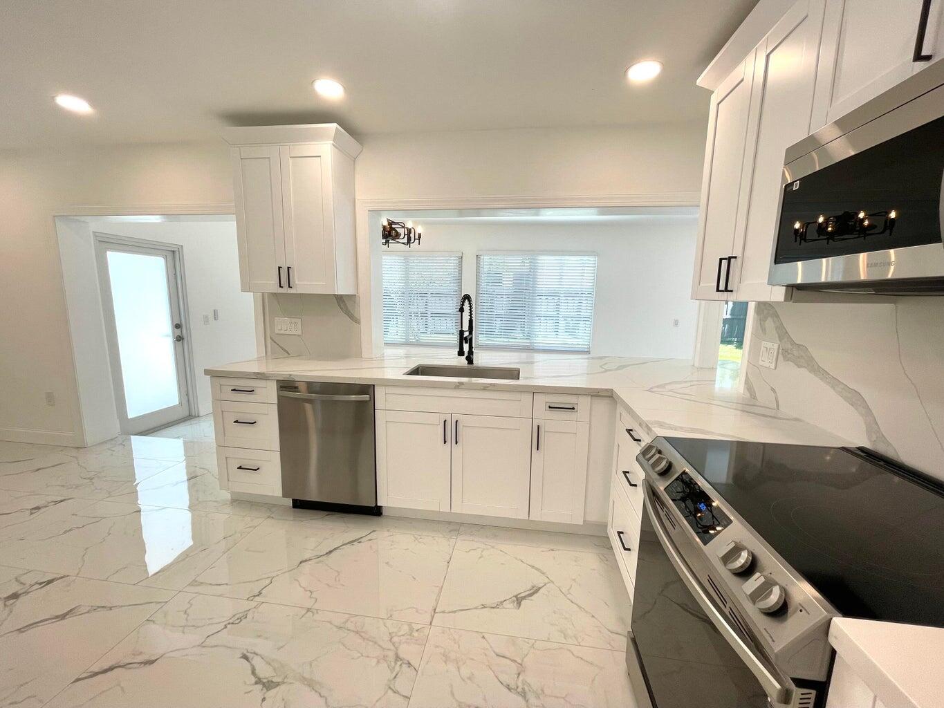861 Northwest 7th Street Boca Raton, FL 33486 - Photo 3 of 18 a kitchen with a sink stove and cabinets