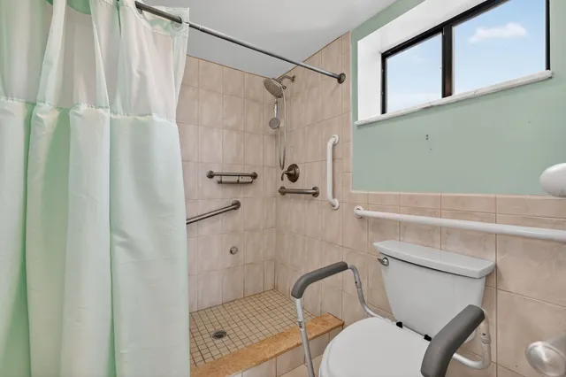 a view of an empty room with window and cabinet