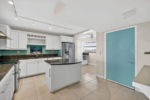 a kitchen with stainless steel appliances granite countertop a refrigerator and a stove top oven