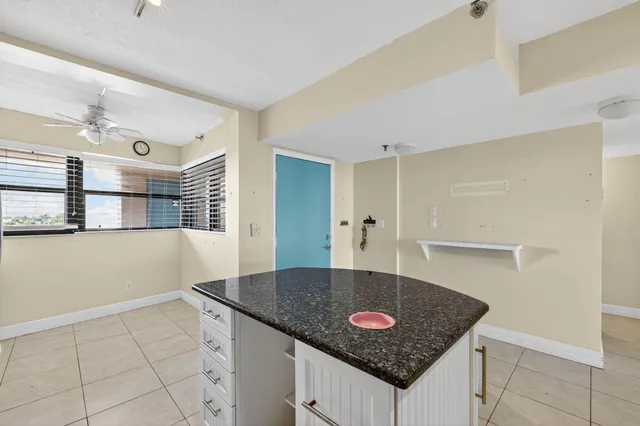 a view of kitchen island with granite countertop a sink