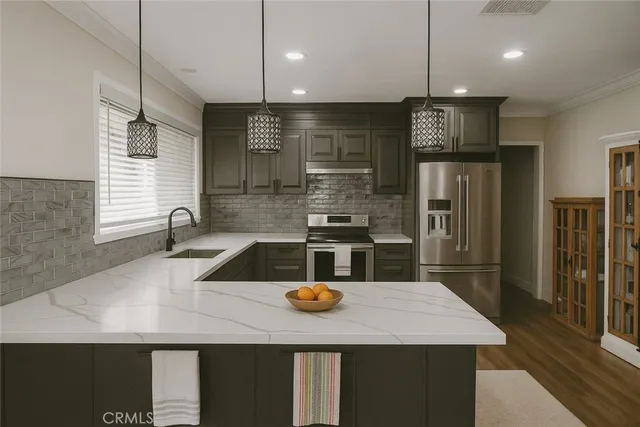 a kitchen with a refrigerator a sink a stove and chairs