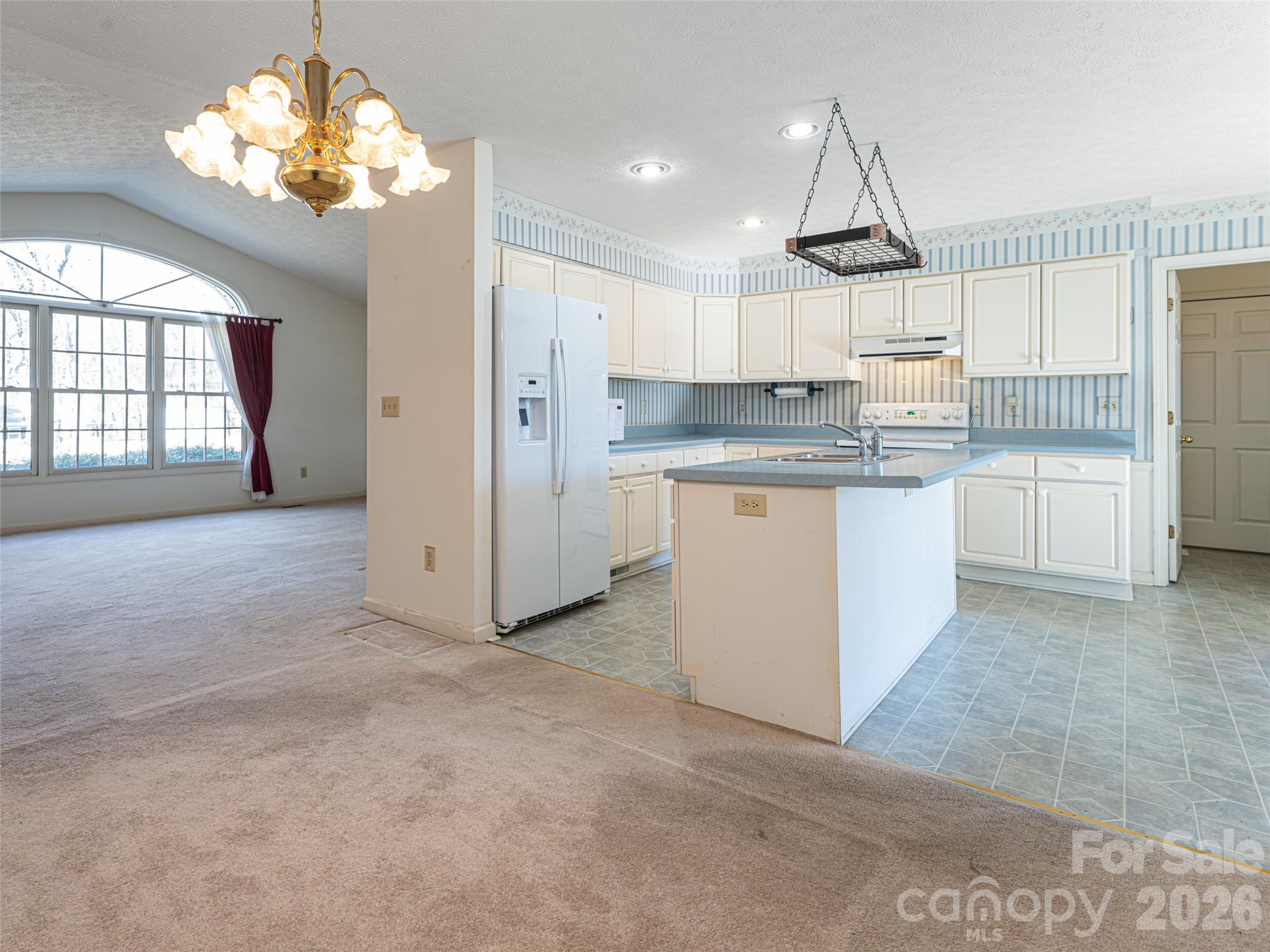 120 Burge Mountain Road Hendersonville, NC 28792 - Photo 13 of 44 a kitchen with kitchen island white cabinets and chandelier