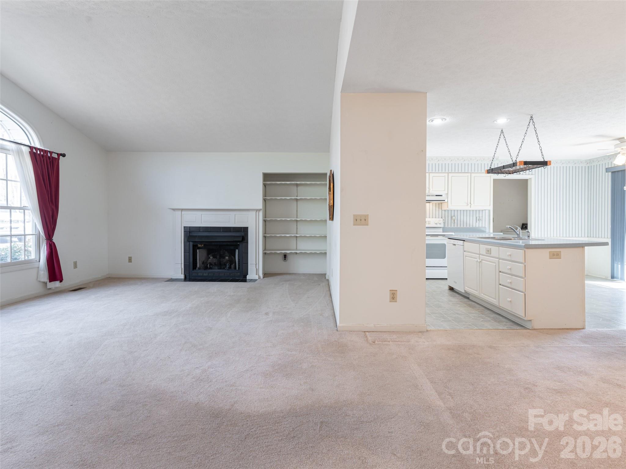 120 Burge Mountain Road Hendersonville, NC 28792 - Photo 6 of 44 an empty room with a fireplace cabinet and window
