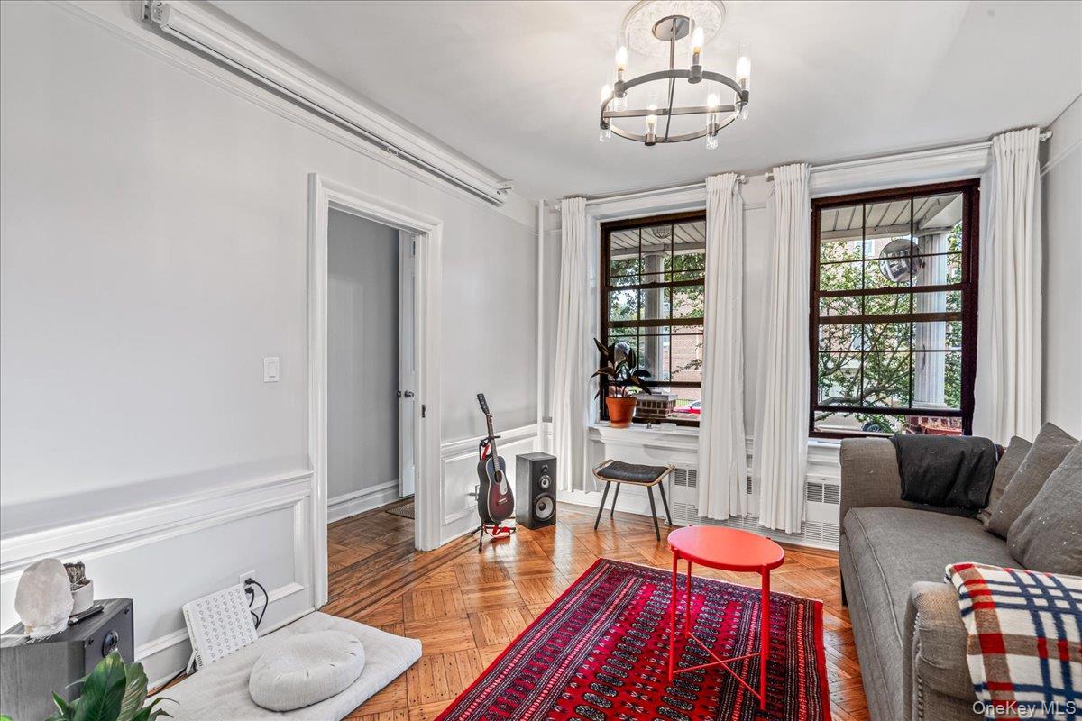 Sitting room featuring a chandelier, a decorative wall, and a wainscoted wall
