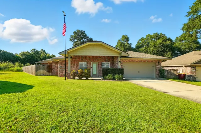 a front view of a house with yard and green space