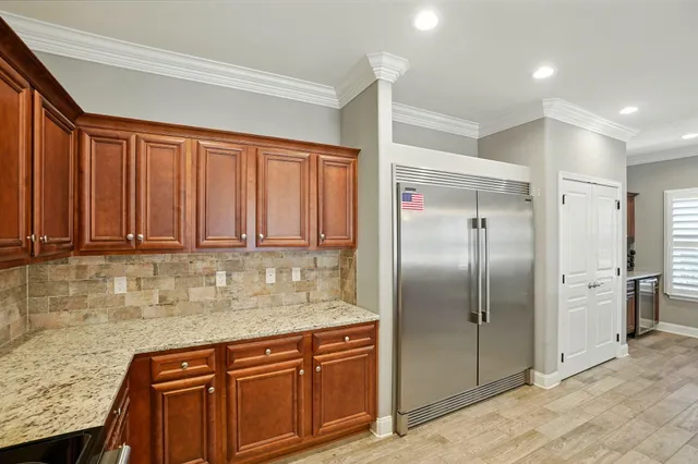 a kitchen with stainless steel appliances granite countertop a refrigerator and a sink