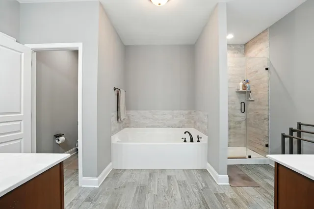 a spacious bathroom with a tub shower and sink