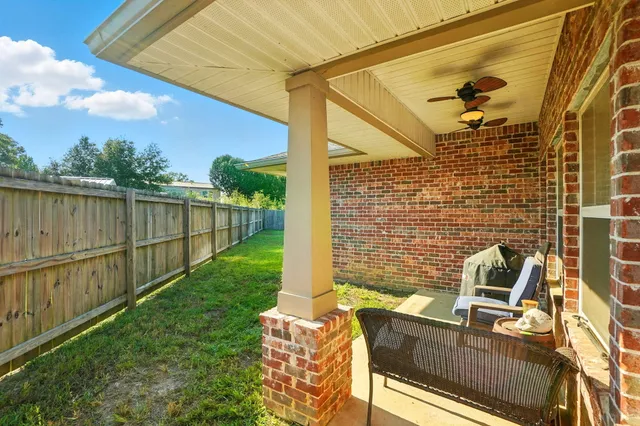 a view of a patio with table and chairs and wooden fence