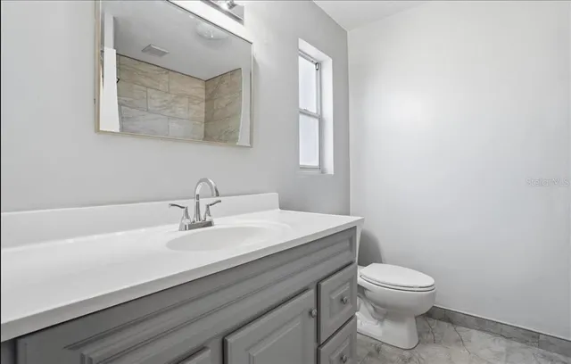 a bathroom with a sink a toilet and mirror