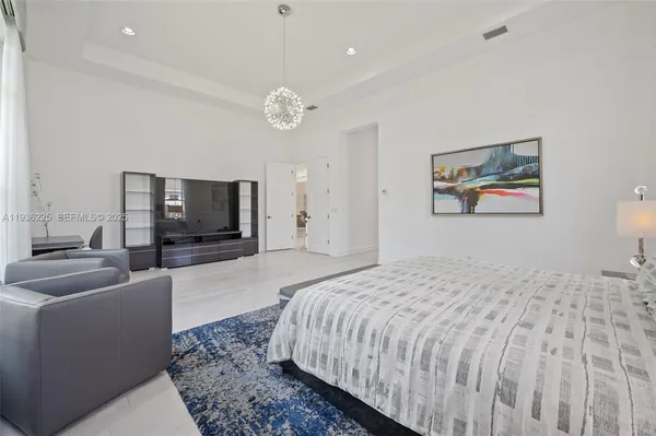 a bedroom with a large bed a flat screen tv and a couch