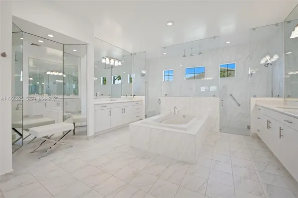 a large white bathroom with a bathtub shower and sink