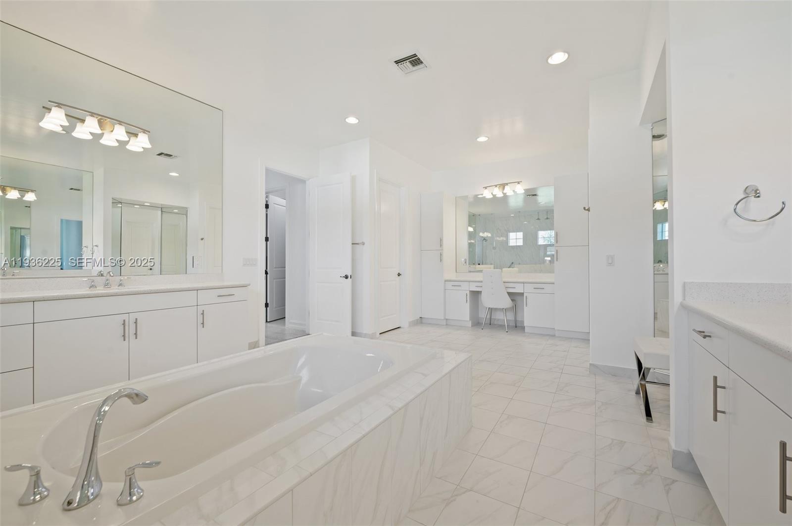 5292 South Sterling Ranch Circle Davie, FL 33314 - Photo 17 of 39 a large white bathroom with a large mirror vanity and shower