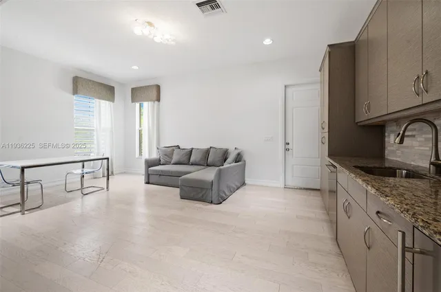 a living room with furniture and a refrigerator
