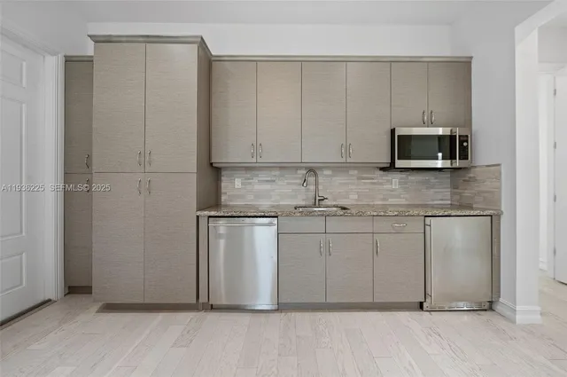 a kitchen with stainless steel appliances granite countertop a stove a sink and a refrigerator