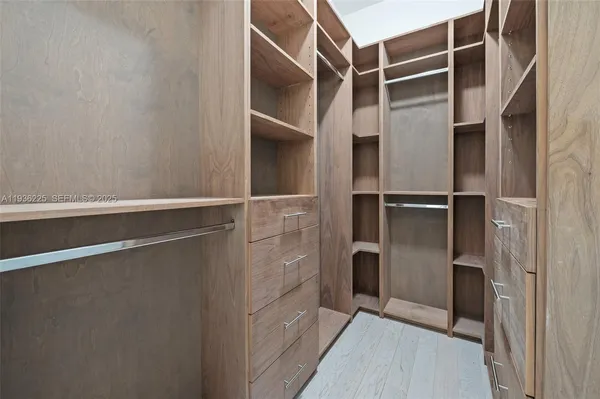 a view of walk in closet with empty room