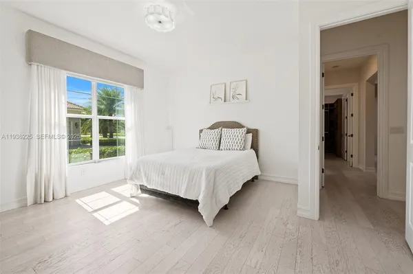 a large bed sitting in a bedroom next to a window
