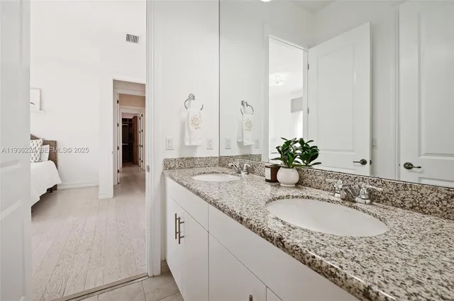 a bathroom with a granite countertop sink and a mirror