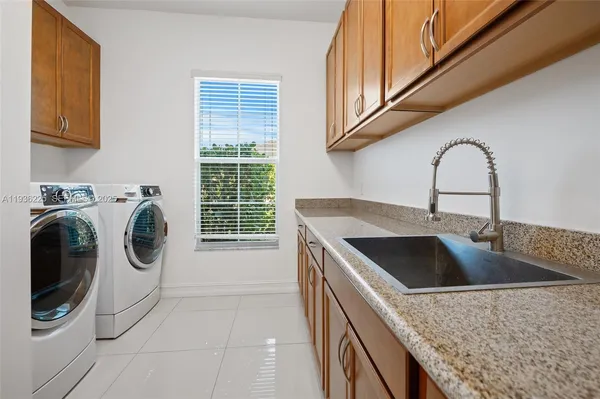 a kitchen with a sink a washer and dryer next to a window