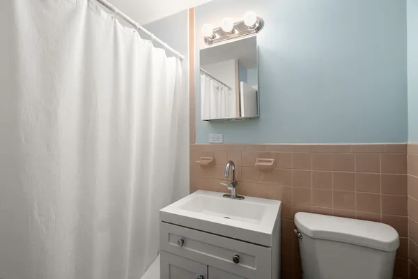 a bathroom with a toilet sink and mirror