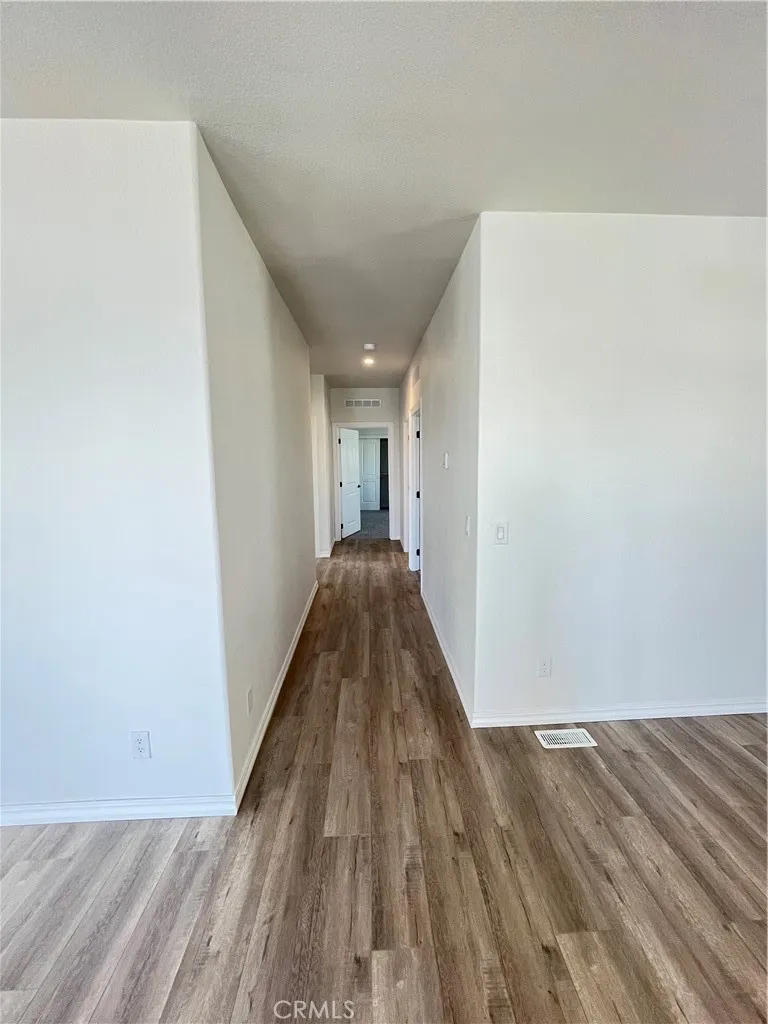 1550 Rimpau, Unit 42 Corona, CA 92881 - Photo 8 of 22 a view of a hallway with wooden floor